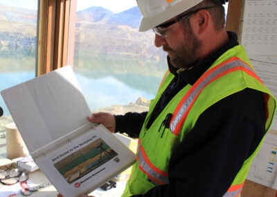 Montana Resources Employee Jeremey Fleege opens one of many waterfowl identification guides lcoated within the bird mitigation station at Montana Resources. Photo by Kayla Lappin, CFWEP.