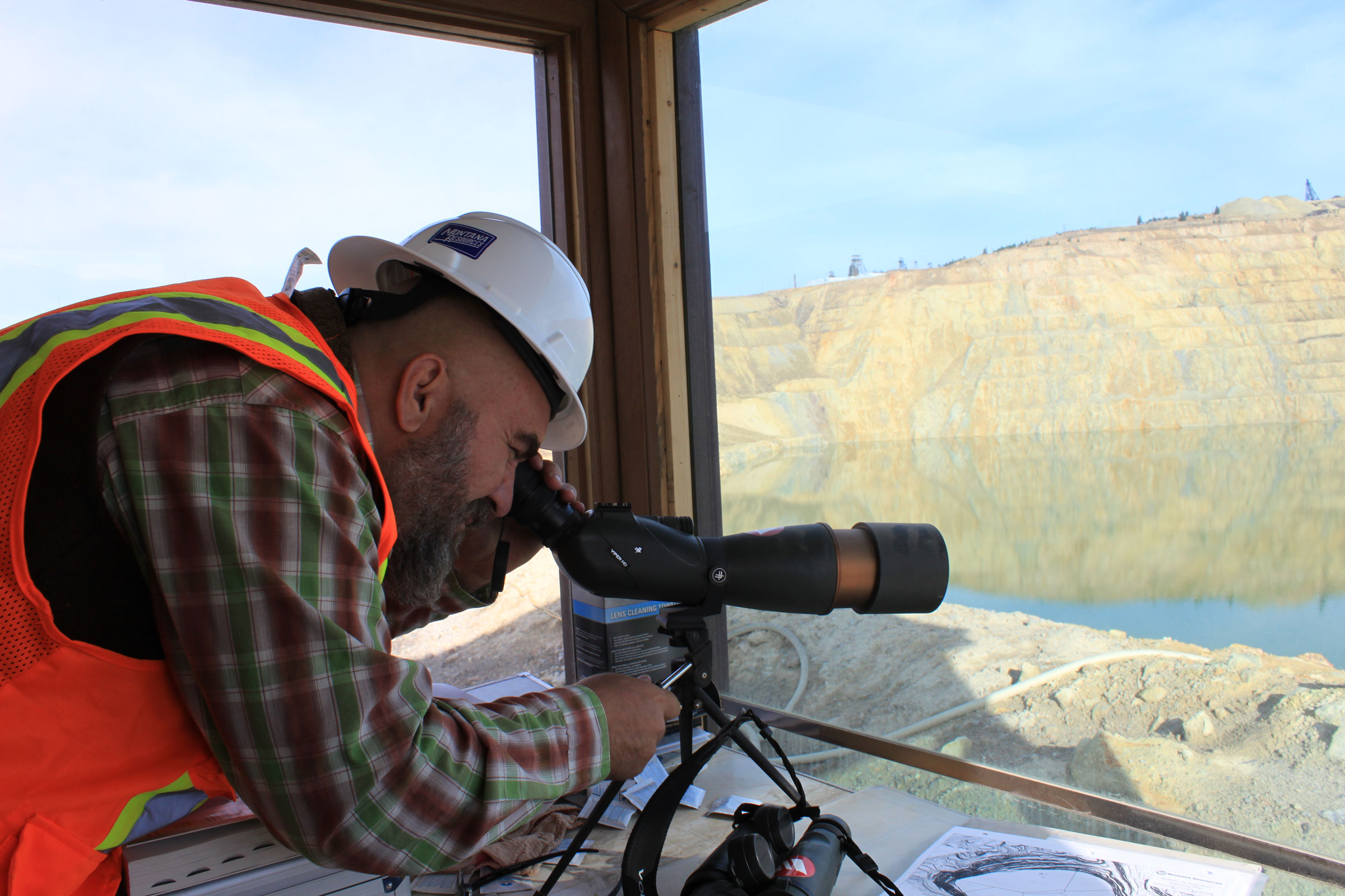 Matt Vincent looks through one of several high powered scopes located within the Bird Mitigation Station at Montana Resources.